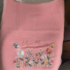 Blush knit baby blanket embroidered with a name and wildflowers