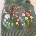 Cream knit baby blanket embroidered with a name and wildflowers