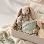 Soft plush bunny with a sage ribbon, presented in a gift box with a personalized knit blanket and wooden keepsakes