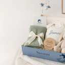 Nuvermi welcome baby gift box containing a personalized knit blanket, bodysuit and Hello World wooden keepsake
